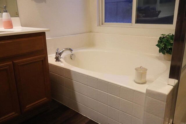 bathroom featuring tiled bath, vanity, and hardwood / wood-style flooring