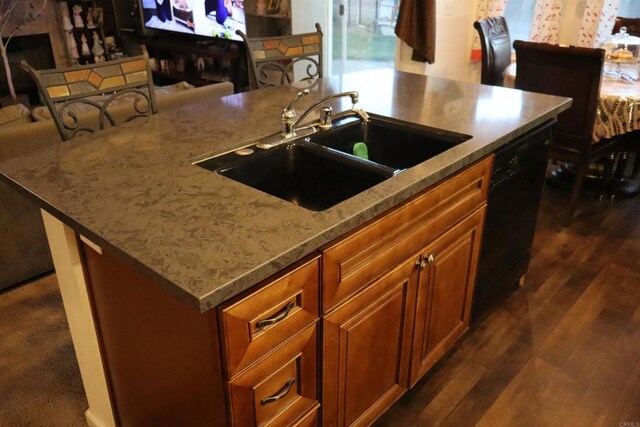 kitchen featuring dark hardwood / wood-style flooring, light stone counters, sink, a center island with sink, and black dishwasher