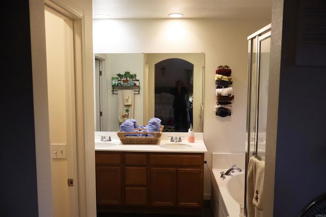 bathroom featuring vanity and independent shower and bath