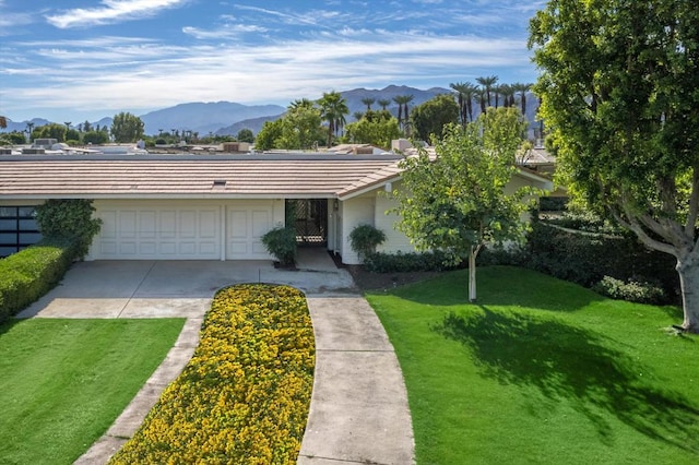 ranch-style home featuring a mountain view, a garage, and a front yard