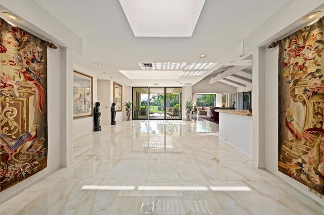 hall featuring lofted ceiling with skylight