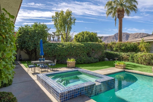 view of swimming pool featuring an in ground hot tub, a mountain view, a yard, and a patio area