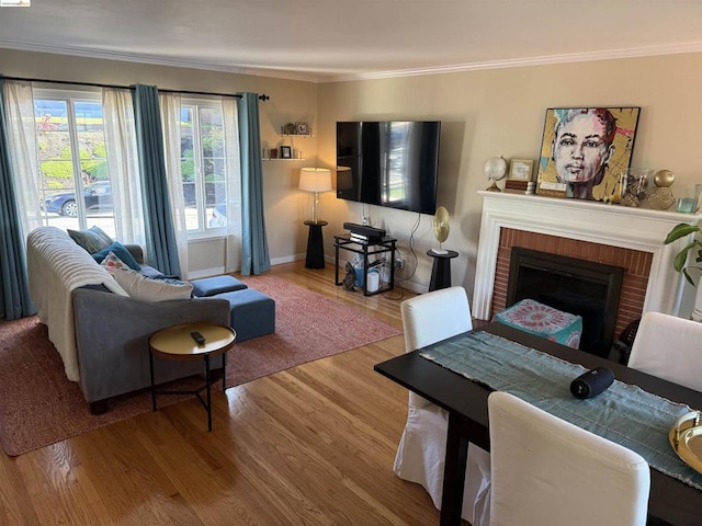 living room with light hardwood / wood-style flooring, ornamental molding, and a brick fireplace