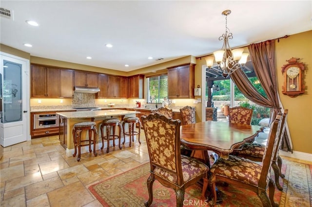 dining area with sink and an inviting chandelier