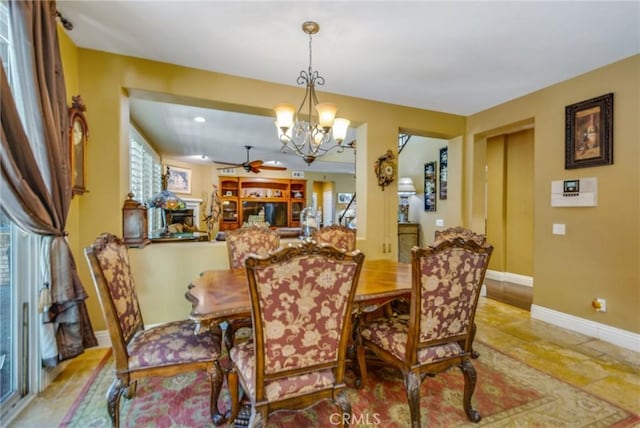 dining room with ceiling fan with notable chandelier