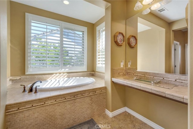 bathroom featuring tile patterned flooring and a relaxing tiled tub