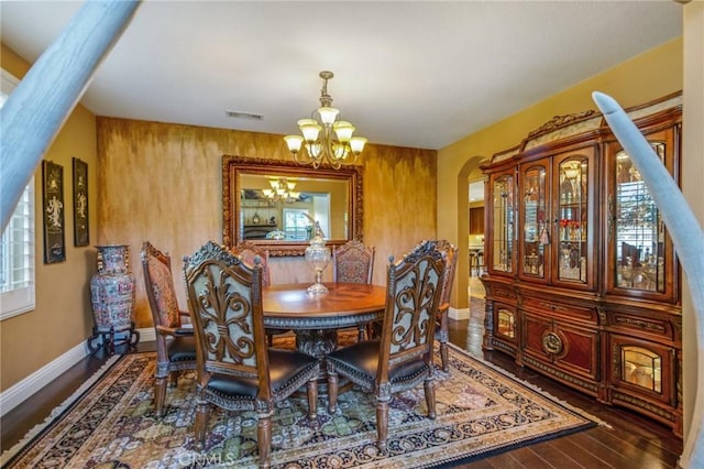 dining room with dark hardwood / wood-style flooring and a notable chandelier