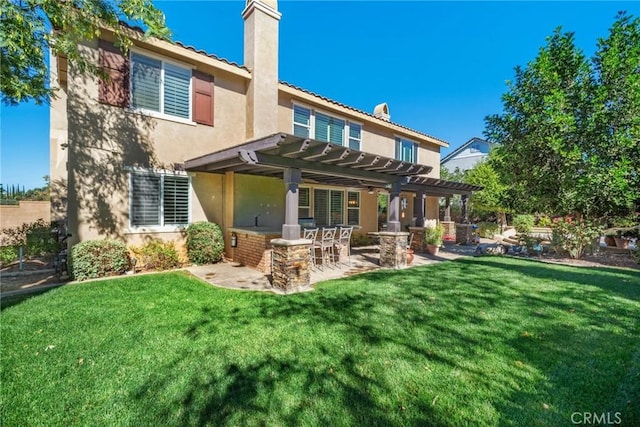 rear view of property with a bar, a pergola, a patio, and a lawn