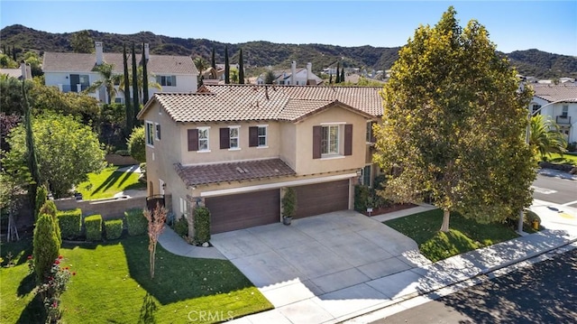 view of front facade with a front yard, a mountain view, and a garage