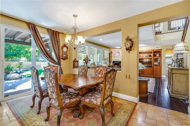 dining space featuring dark hardwood / wood-style flooring, a wealth of natural light, and a notable chandelier