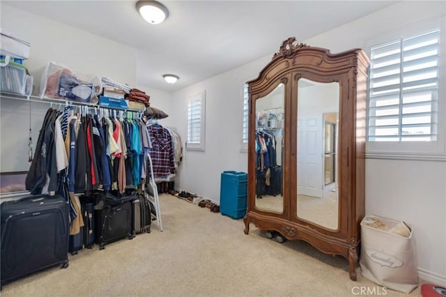 walk in closet featuring light colored carpet