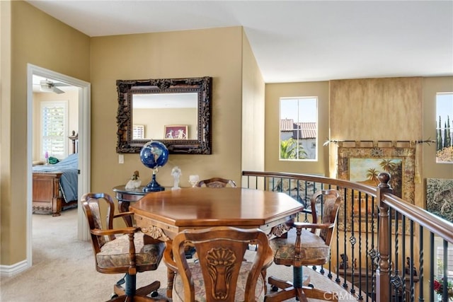 dining space with light carpet and ceiling fan