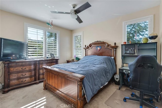 carpeted bedroom with ceiling fan and multiple windows