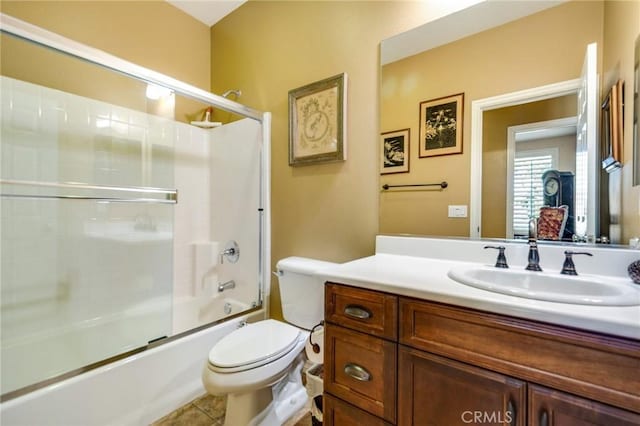 full bathroom featuring tile patterned floors, vanity, enclosed tub / shower combo, and toilet