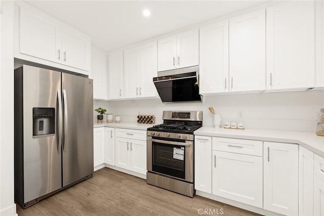 kitchen with white cabinets, light wood-type flooring, stainless steel appliances, and range hood