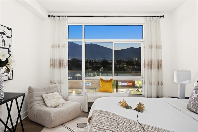 bedroom featuring multiple windows, a mountain view, and hardwood / wood-style floors