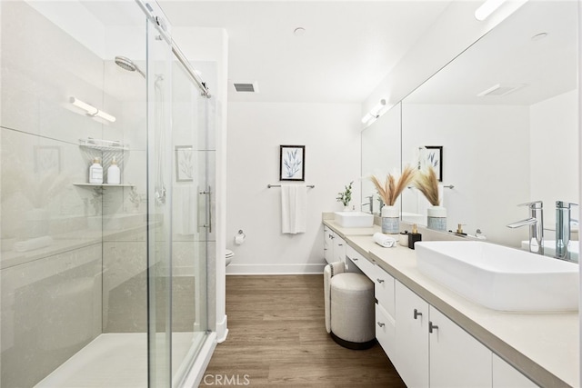 bathroom with vanity, hardwood / wood-style flooring, toilet, and a shower with door