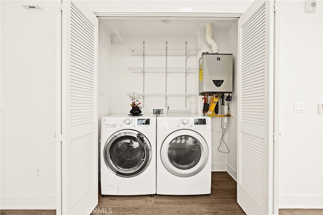 clothes washing area featuring separate washer and dryer, tankless water heater, and dark hardwood / wood-style floors