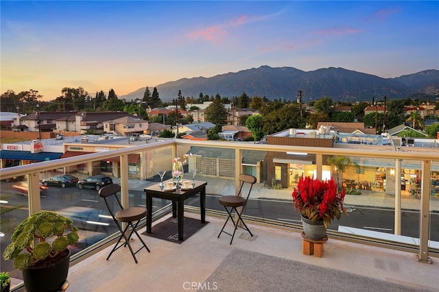 balcony at dusk featuring a mountain view