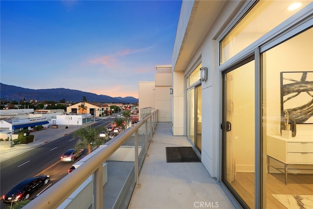 balcony at dusk featuring a mountain view