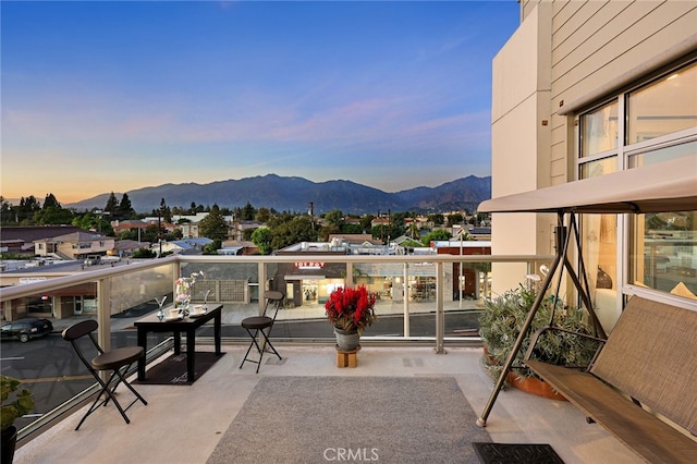 patio terrace at dusk with a mountain view and a balcony