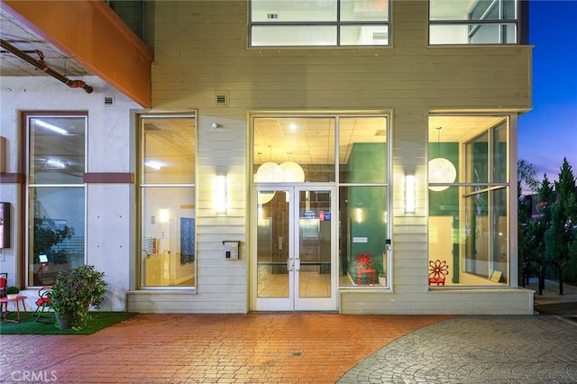 exterior entry at dusk with a patio area and french doors