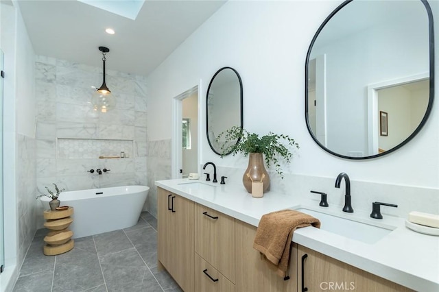 bathroom featuring tile patterned floors, a washtub, tile walls, and vanity