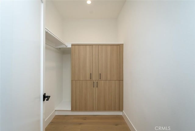 spacious closet with light hardwood / wood-style floors