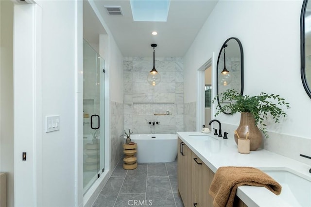 bathroom featuring a skylight, vanity, tile walls, and shower with separate bathtub