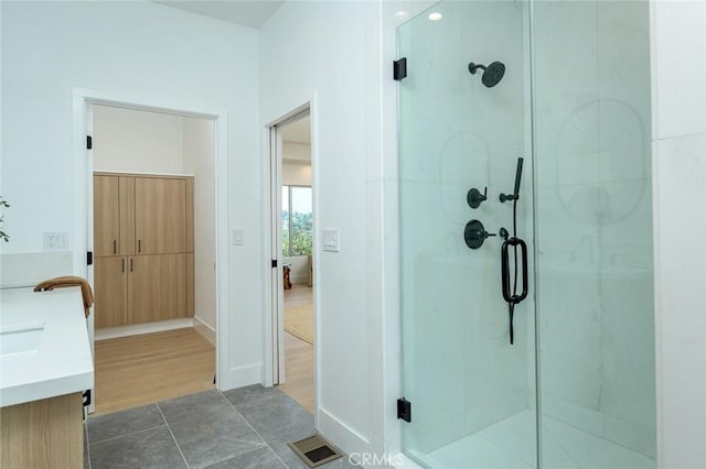 bathroom with vanity, an enclosed shower, and hardwood / wood-style flooring