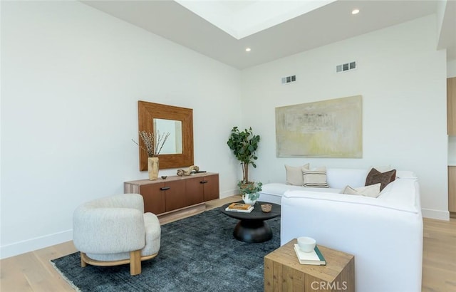 living area with a high ceiling and light hardwood / wood-style flooring