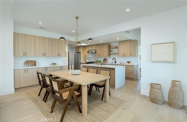 dining room with sink and light hardwood / wood-style floors