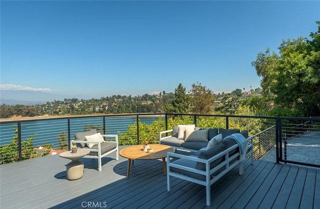 deck featuring outdoor lounge area and a water view