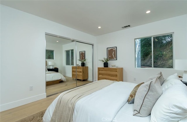 bedroom with light wood-type flooring and a closet