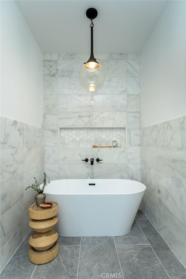 bathroom featuring a washtub and tile walls