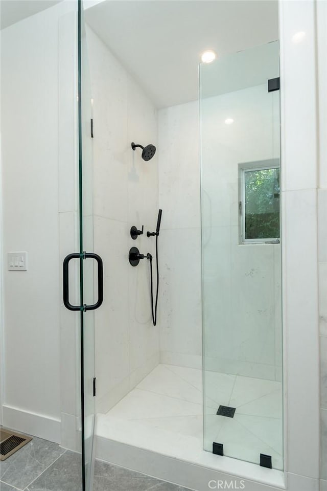 bathroom with tile patterned flooring and a shower with door