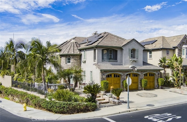 505 Lowe Dr, Placentia, CA 92870 - view of front of house featuring stone siding, a garage, stucco siding, concrete driveway, and roof mounted solar panels