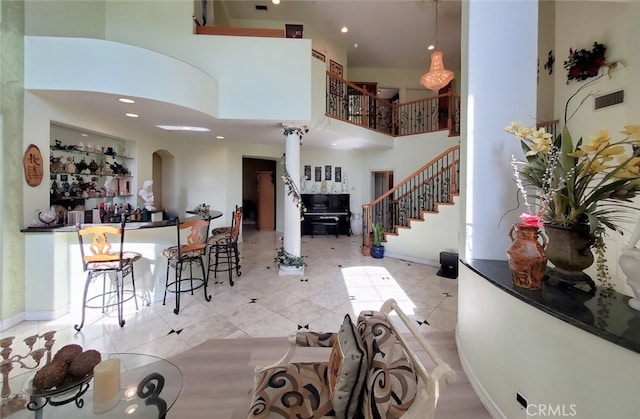 505 Lowe Dr, Placentia, CA 92870 - tiled living room featuring stairway, arched walkways, a high ceiling, recessed lighting, and bar area