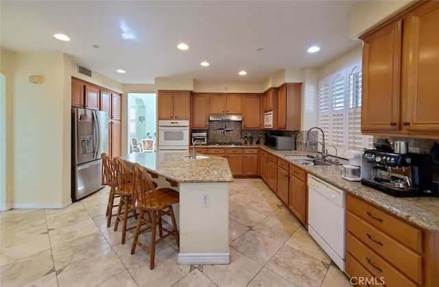 505 Lowe Dr, Placentia, CA 92870 - kitchen with appliances with stainless steel finishes, under cabinet range hood, decorative backsplash, light stone counters, and recessed lighting