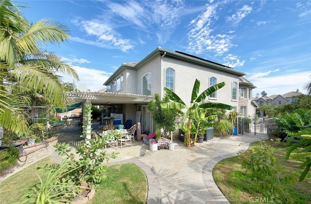 505 Lowe Dr, Placentia, CA 92870 - rear view of property featuring stucco siding, a pergola, a patio, a gate, and solar panels