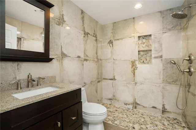 full bath with vanity, recessed lighting, a tile shower, tile walls, and toilet