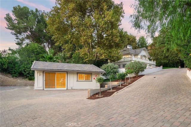 exterior space featuring an outdoor structure and decorative driveway