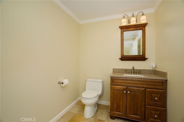 bathroom with vanity, crown molding, toilet, and baseboards