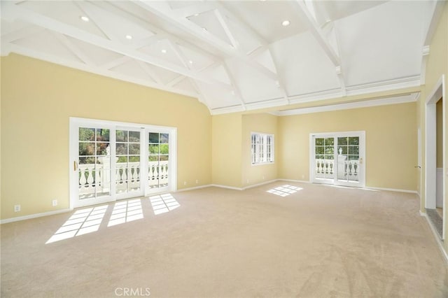 empty room with carpet, baseboards, and high vaulted ceiling