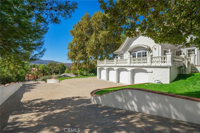 surrounding community with a mountain view, driveway, and a yard