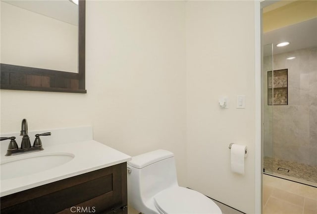 bathroom featuring vanity, toilet, recessed lighting, and tiled shower