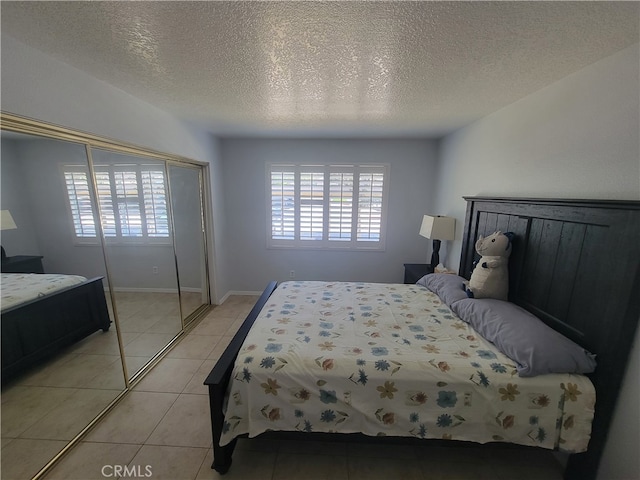 tiled bedroom featuring a closet and a textured ceiling