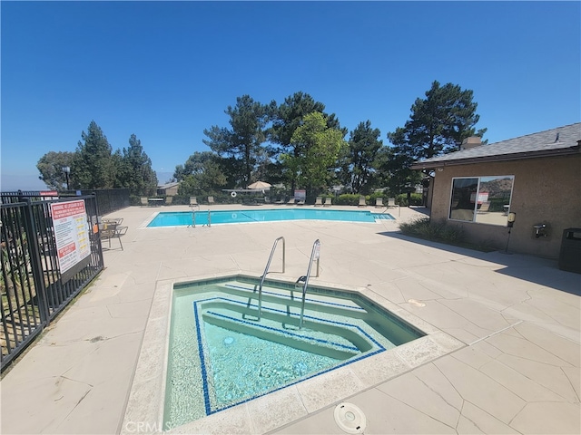 view of pool featuring a patio and a community hot tub