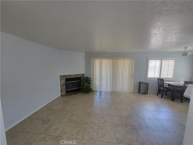 unfurnished living room featuring a textured ceiling, light tile patterned floors, and a fireplace