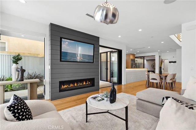 living room with light wood-type flooring and a fireplace